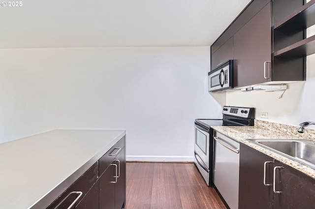 255 SW Harrison St Unit 3C, Portland, OR 97201 - kitchen featuring stainless steel appliances, light countertops, open shelves, a sink, and dark wood-type flooring