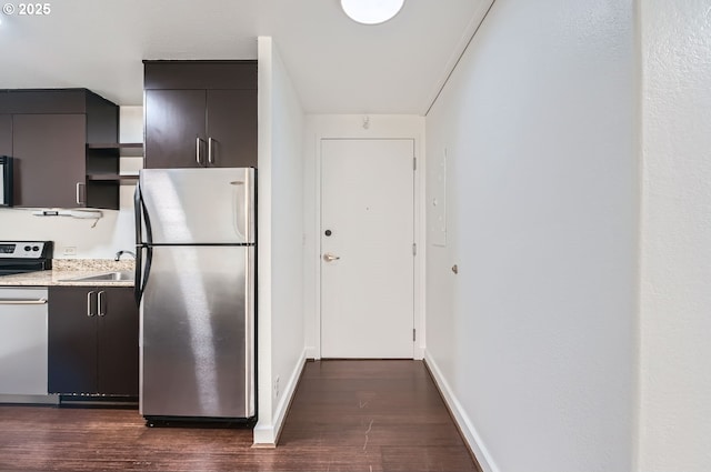 255 SW Harrison St Unit 3C, Portland, OR 97201 - kitchen featuring stainless steel appliances, dark wood-type flooring, a sink, light countertops, and baseboards
