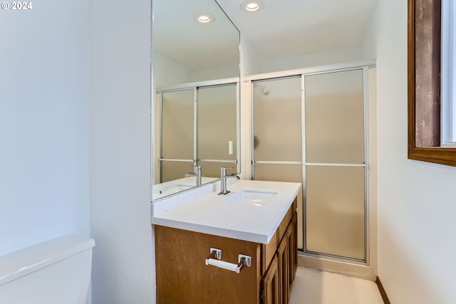 bathroom featuring vanity, recessed lighting, a shower stall, and toilet