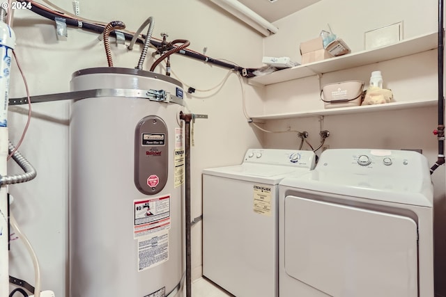 washroom featuring washing machine and dryer, water heater, and laundry area