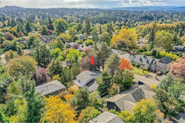 drone / aerial view featuring a residential view and a view of trees