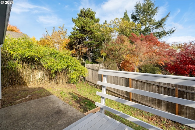 wooden deck with a fenced backyard