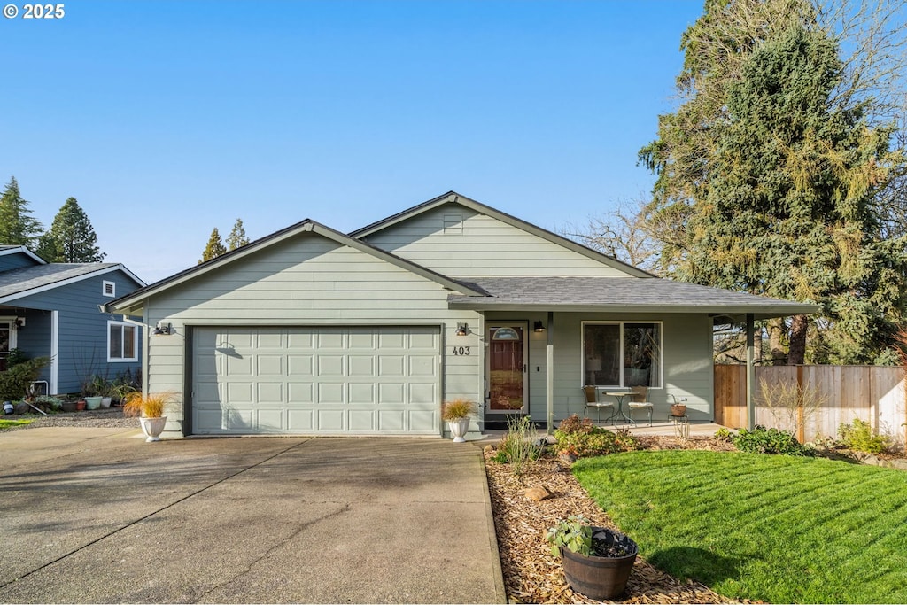 ranch-style home featuring a front yard, a garage, and covered porch