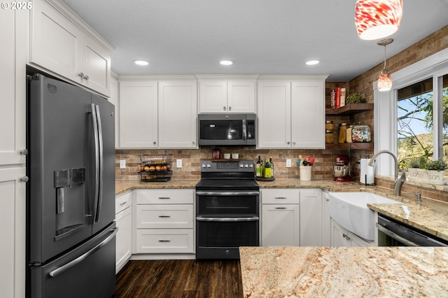 kitchen featuring appliances with stainless steel finishes, dark hardwood / wood-style flooring, white cabinets, decorative light fixtures, and sink