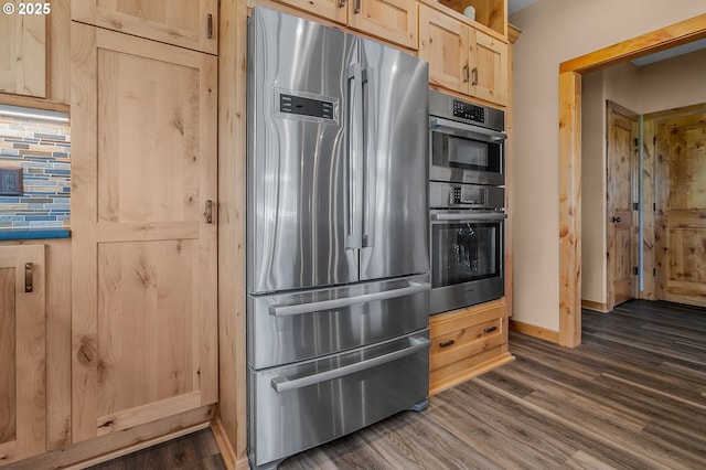 kitchen with appliances with stainless steel finishes, light brown cabinets, dark hardwood / wood-style flooring, and decorative backsplash