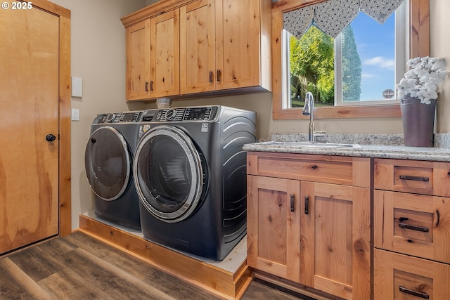 laundry area with cabinets, dark hardwood / wood-style flooring, sink, and washer and dryer