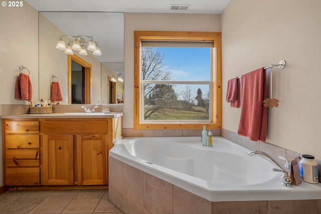 bathroom featuring vanity, tile patterned floors, and tiled bath