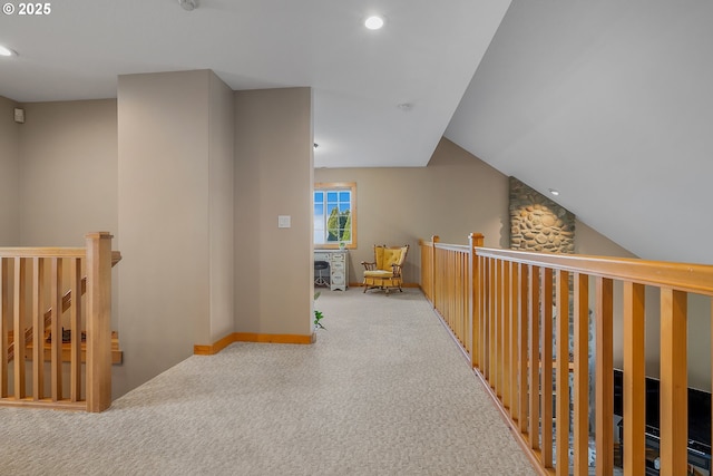 hallway featuring lofted ceiling and light carpet