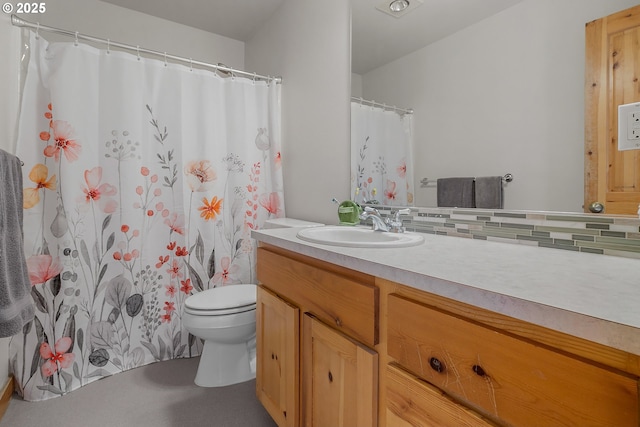 bathroom featuring vanity, backsplash, and toilet