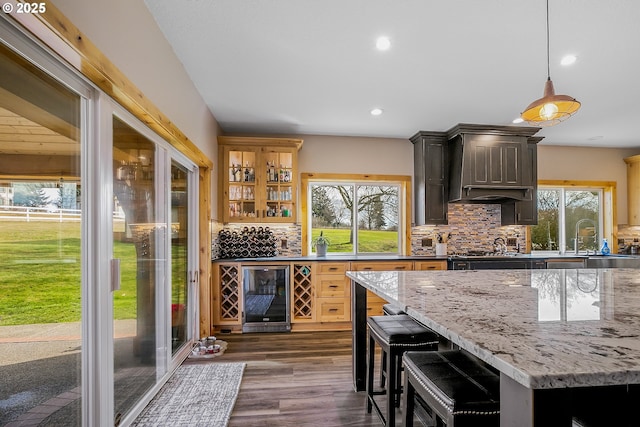 bar with decorative light fixtures, sink, wine cooler, dark hardwood / wood-style flooring, and backsplash