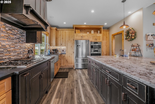 kitchen with pendant lighting, hardwood / wood-style flooring, appliances with stainless steel finishes, ventilation hood, and light brown cabinetry