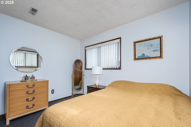 bedroom featuring dark carpet and a textured ceiling