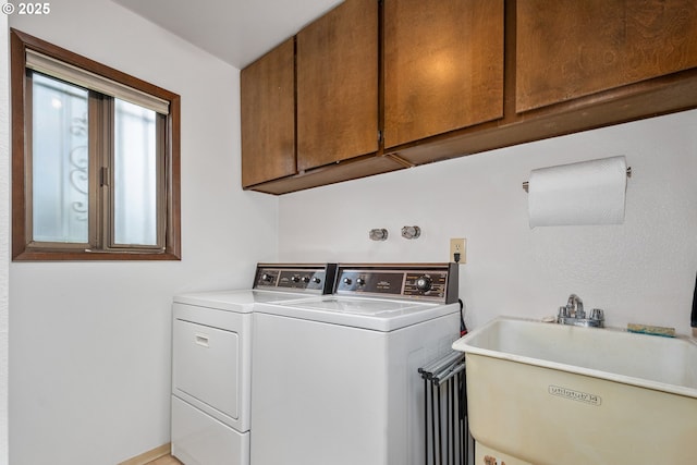 washroom featuring washer and dryer, sink, and cabinets