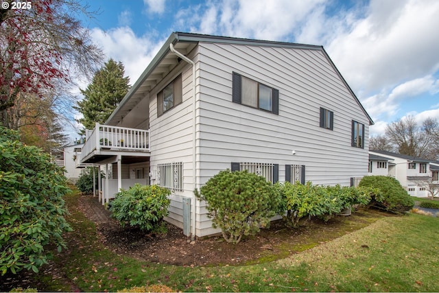 view of property exterior with a balcony and a yard