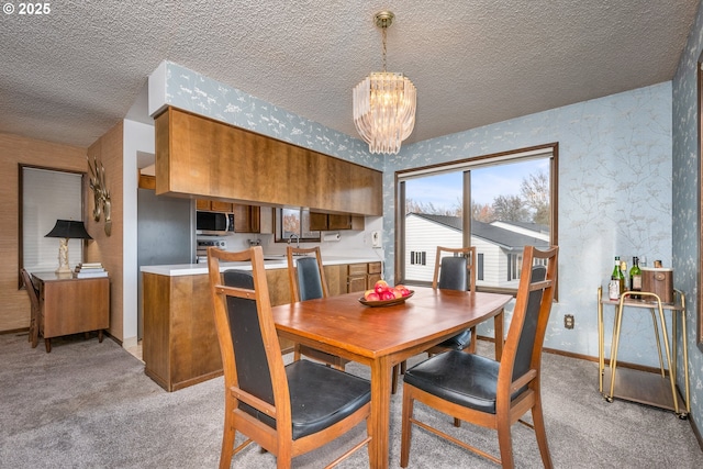 dining area featuring a notable chandelier, a textured ceiling, light carpet, and sink