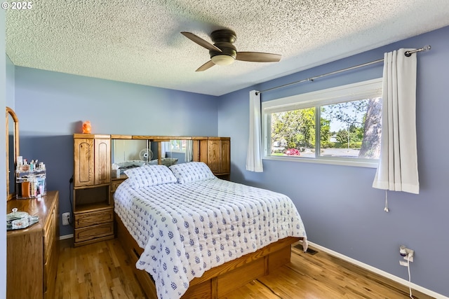 173 NE 32nd Ave, Hillsboro, OR 97124 - bedroom with wood finished floors, a textured ceiling, baseboards, and ceiling fan