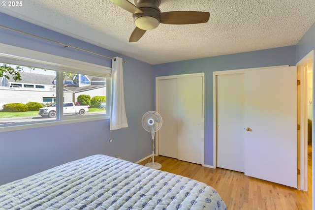 173 NE 32nd Ave, Hillsboro, OR 97124 - bedroom with multiple closets, a textured ceiling, wood finished floors, and a ceiling fan