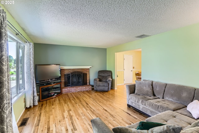 173 NE 32nd Ave, Hillsboro, OR 97124 - living area with a textured ceiling, wood finished floors, and a brick fireplace