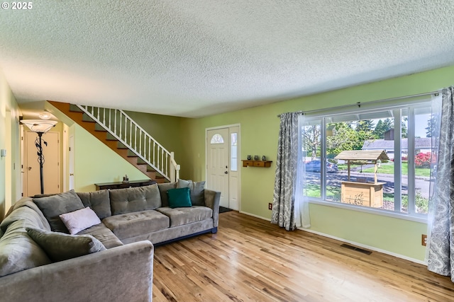 173 NE 32nd Ave, Hillsboro, OR 97124 - living room featuring a textured ceiling, stairway, wood finished floors, and baseboards