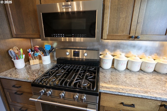 kitchen featuring light stone counters and stainless steel appliances