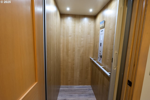 interior details featuring recessed lighting, elevator, and wood finished floors