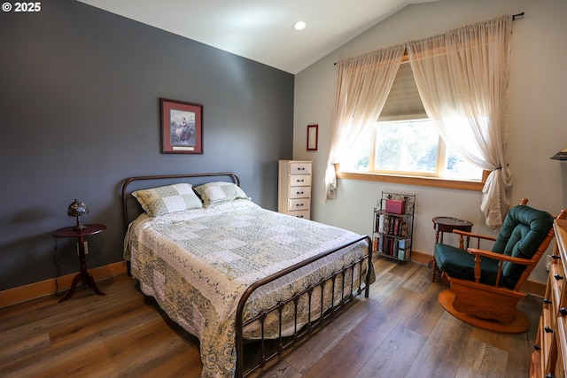 bedroom with lofted ceiling, wood-type flooring, and baseboards