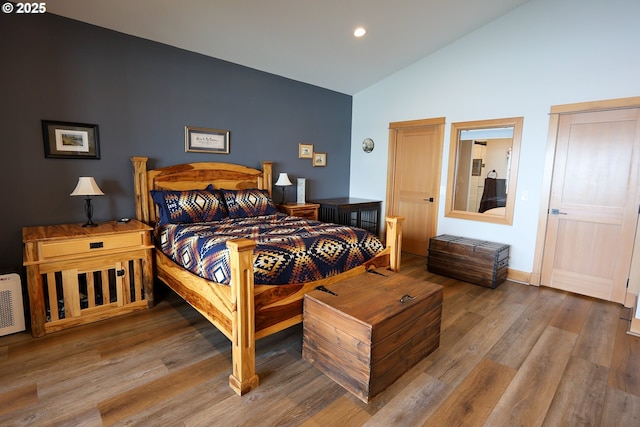 bedroom with high vaulted ceiling, recessed lighting, baseboards, and wood finished floors