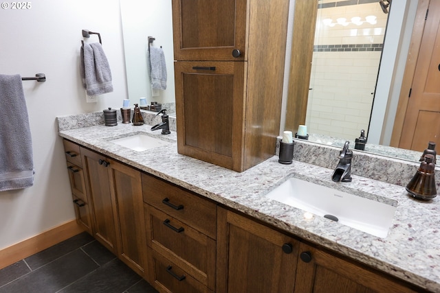 full bath with double vanity, baseboards, a sink, and tile patterned floors