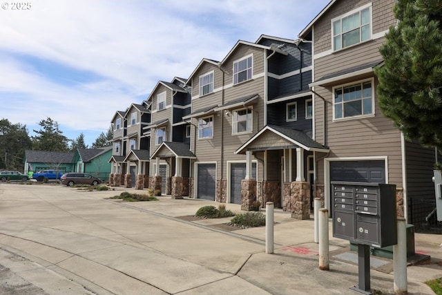 view of building exterior with a garage, driveway, and a residential view