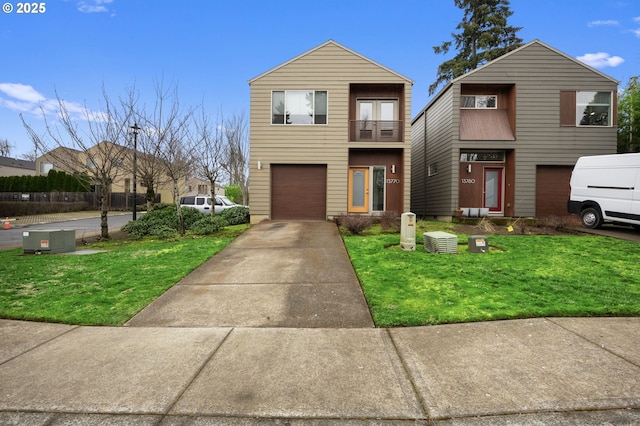 view of front facade with concrete driveway, a balcony, an attached garage, and a front lawn