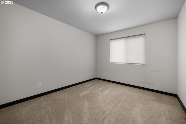 carpeted empty room with baseboards