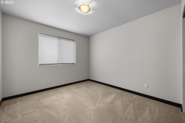 carpeted empty room with baseboards