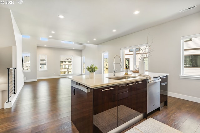kitchen with visible vents, modern cabinets, light countertops, dark brown cabinets, and a sink