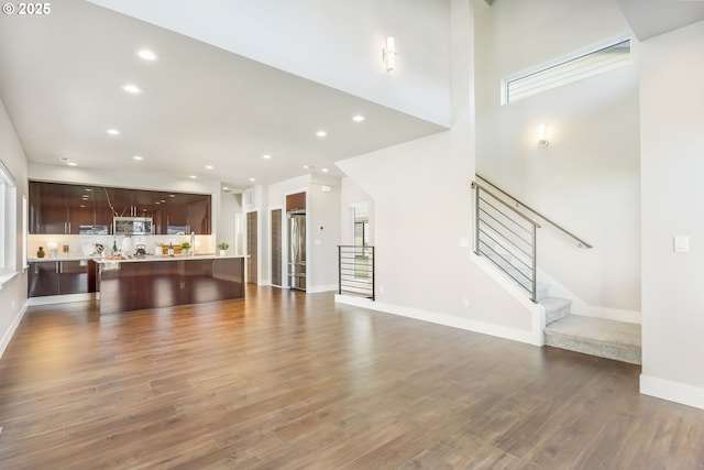 living room with dark wood-type flooring, recessed lighting, and stairs