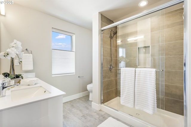 full bathroom featuring toilet, a shower stall, baseboards, and vanity