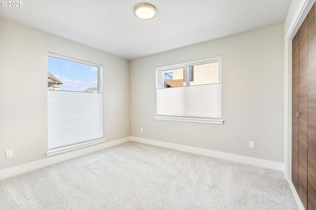 carpeted empty room featuring baseboards