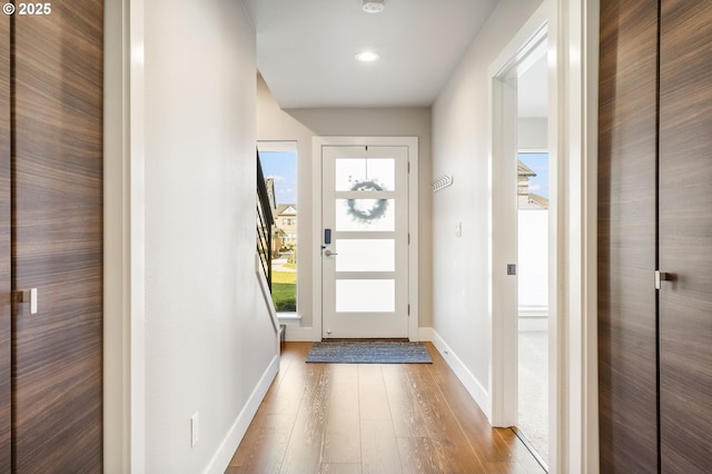 doorway to outside featuring baseboards, wood finished floors, and recessed lighting