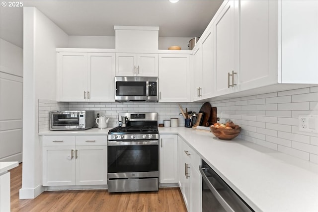 7510 NW Lauren Ave, Portland, OR 97229 - kitchen featuring stainless steel appliances, light countertops, and white cabinetry