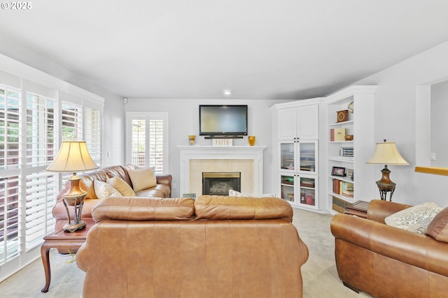 living area featuring light carpet and a glass covered fireplace