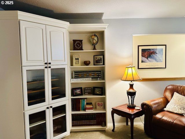 living area with baseboards and light colored carpet