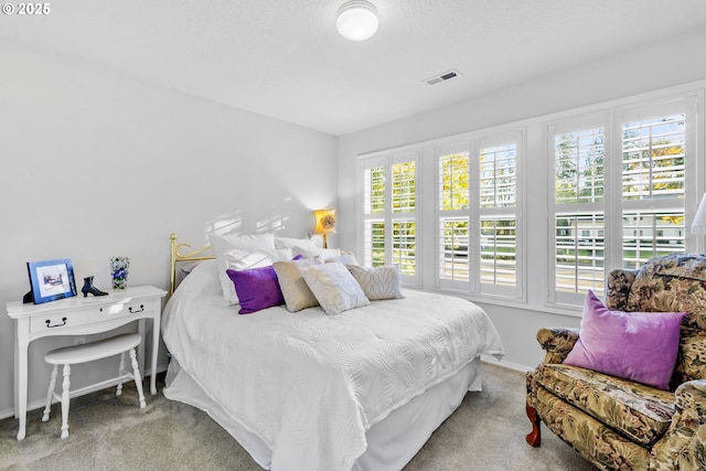 carpeted bedroom featuring visible vents and baseboards