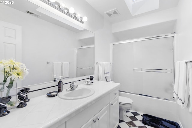 full bathroom featuring visible vents, bath / shower combo with glass door, toilet, tile patterned floors, and vanity