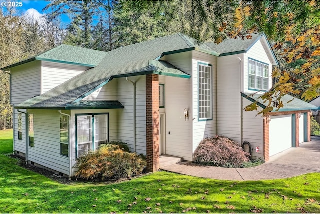 view of front of house with a garage, driveway, roof with shingles, and a front yard