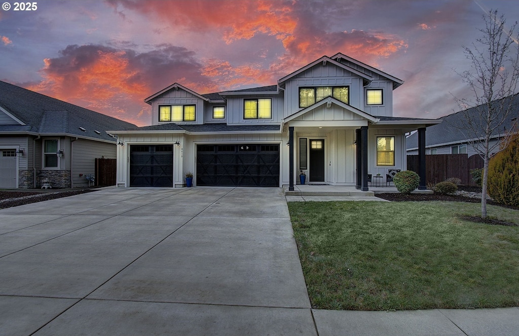 view of front of home featuring a garage, a lawn, and covered porch