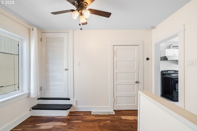 interior space featuring a ceiling fan, wood finished floors, and baseboards