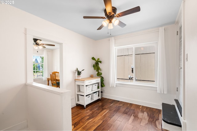 corridor with dark wood-style flooring and baseboards