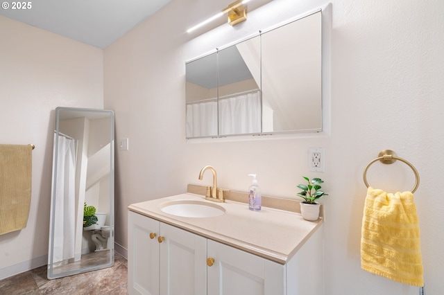 full bath featuring vanity and baseboards