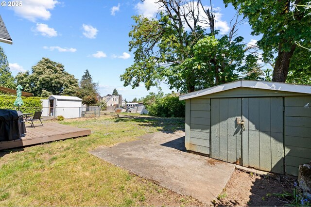 view of yard with a shed, a deck, and an outbuilding