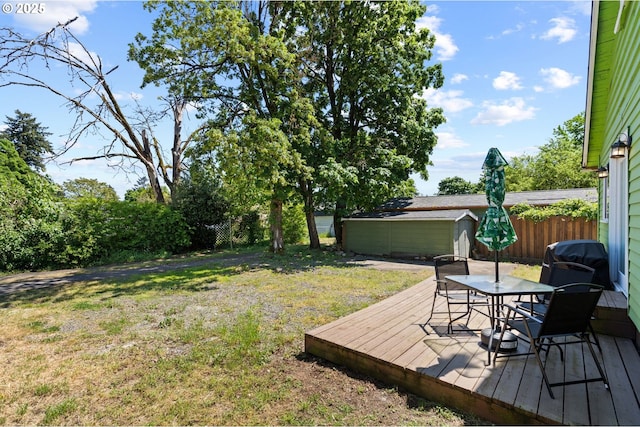 view of yard with an outdoor structure, a deck, a shed, and outdoor dining space