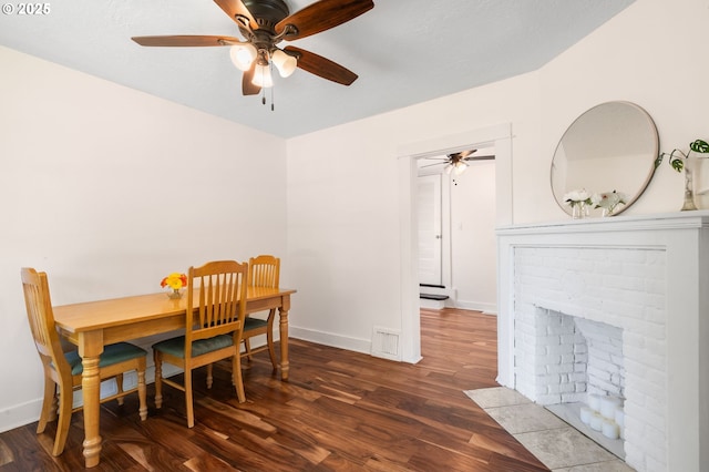 dining room with a ceiling fan, wood finished floors, and baseboards